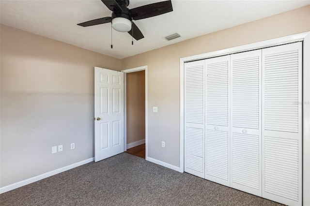 unfurnished bedroom featuring ceiling fan, a closet, and dark colored carpet