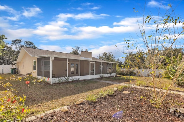 back of property featuring a lawn and a sunroom