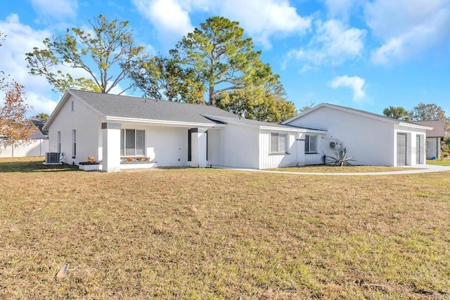 rear view of property featuring cooling unit and a yard