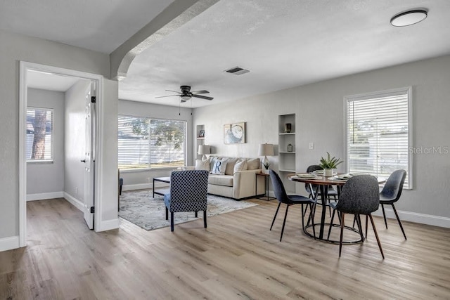 living room with ceiling fan, a healthy amount of sunlight, and light wood-type flooring