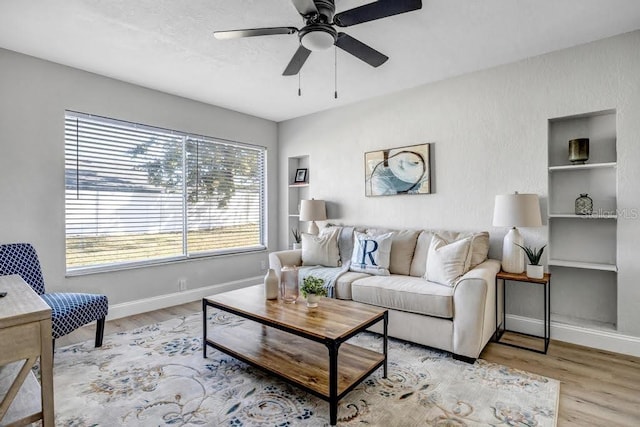 living room featuring ceiling fan and light hardwood / wood-style floors