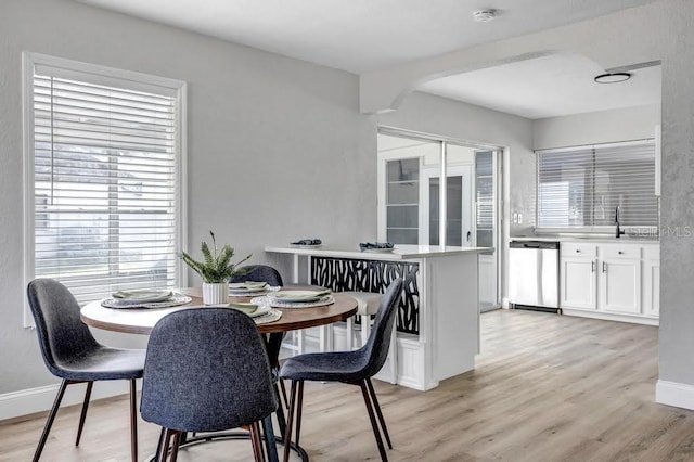 dining area with light hardwood / wood-style flooring and sink