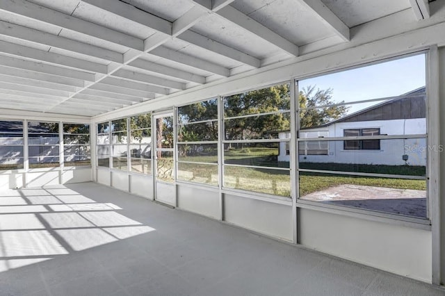 unfurnished sunroom featuring beamed ceiling