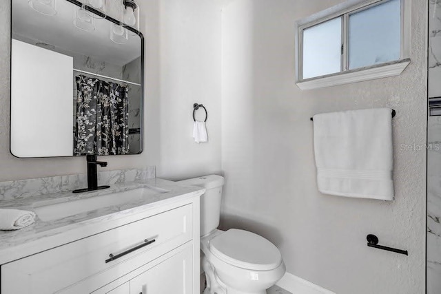 bathroom with a shower with shower curtain, vanity, and toilet