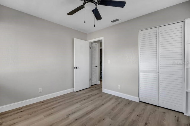 unfurnished bedroom with light wood-type flooring, a closet, and ceiling fan