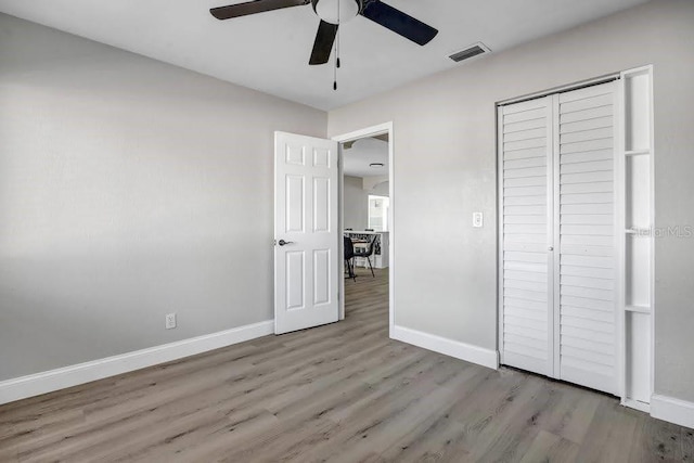 unfurnished bedroom with ceiling fan, light hardwood / wood-style floors, and a closet