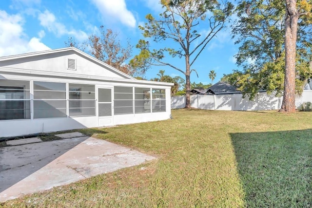 view of yard with a sunroom and a patio area