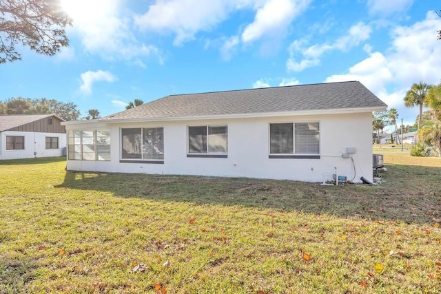 back of house with central AC and a yard