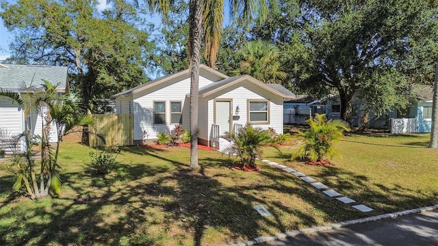 bungalow-style house featuring a front yard and fence