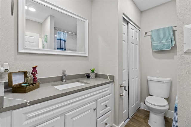 bathroom featuring hardwood / wood-style floors, vanity, and toilet