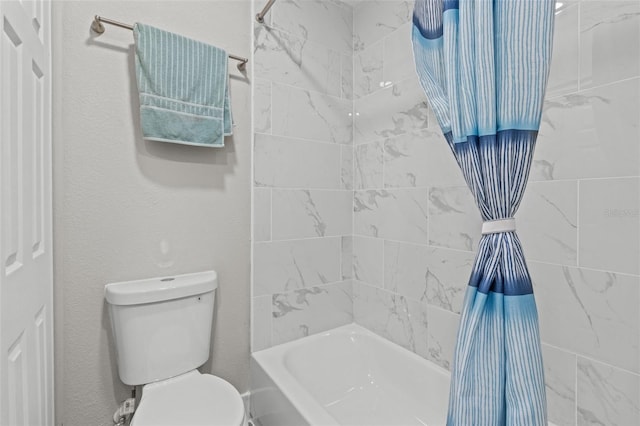 bathroom with toilet and tiled shower / bath