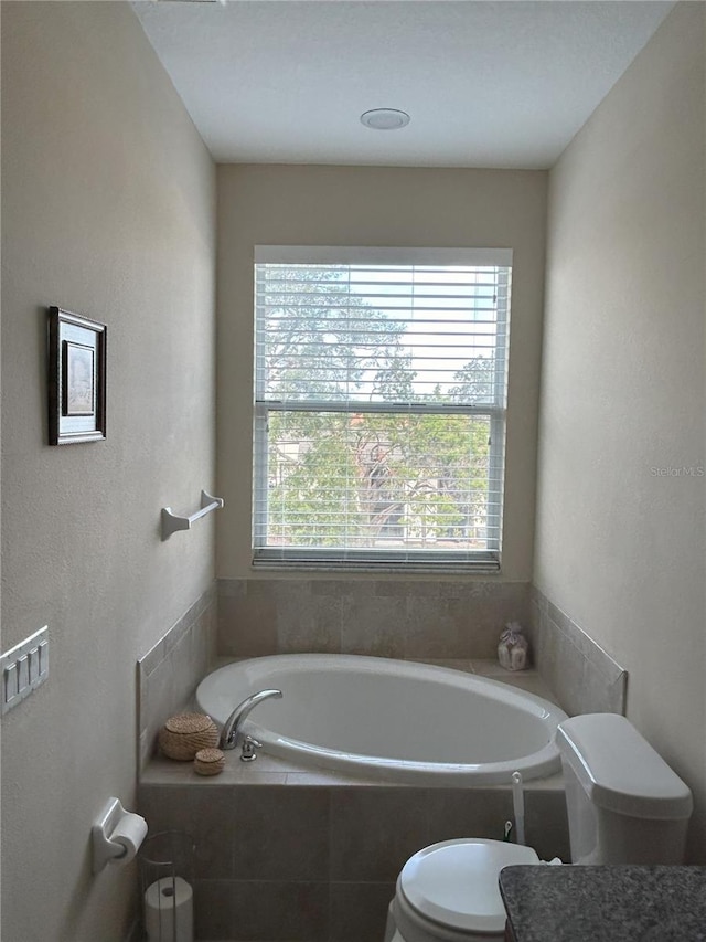 bathroom with a relaxing tiled tub and toilet