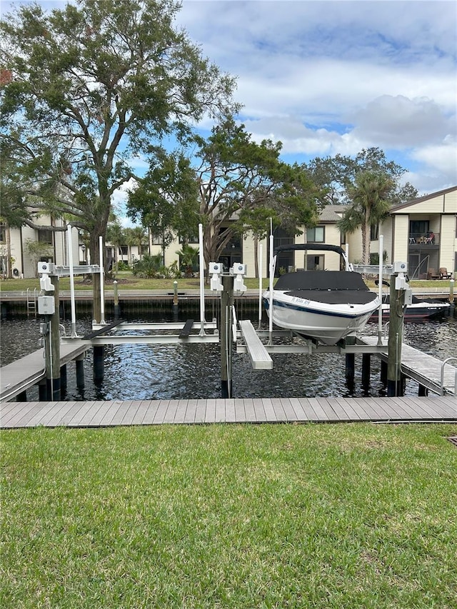 view of dock with a yard and a water view