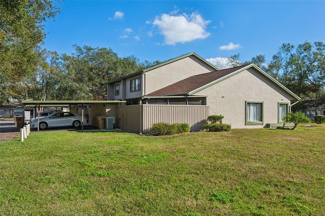 view of property exterior featuring central air condition unit, a carport, and a lawn