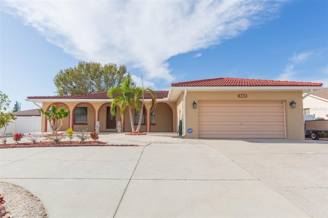 mediterranean / spanish-style house with a garage