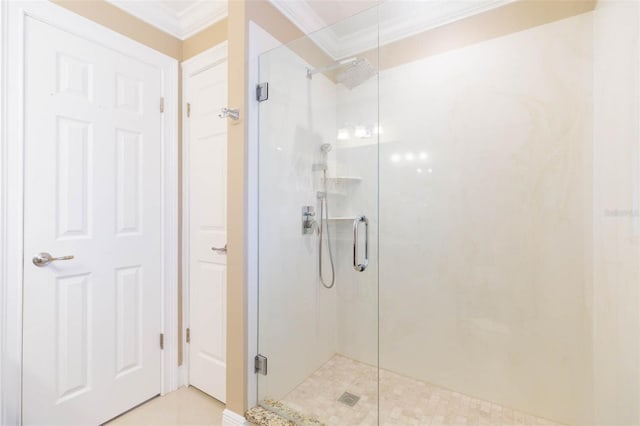 bathroom featuring a shower with door and crown molding