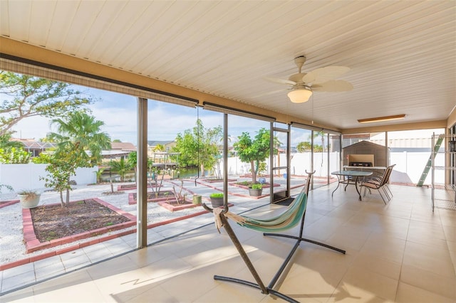 unfurnished sunroom with ceiling fan