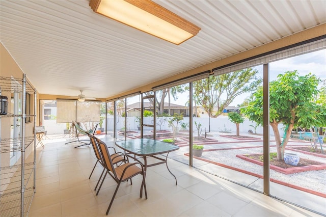 unfurnished sunroom with ceiling fan and a water view