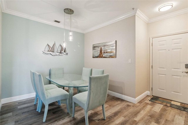 dining area featuring a chandelier, hardwood / wood-style floors, and crown molding