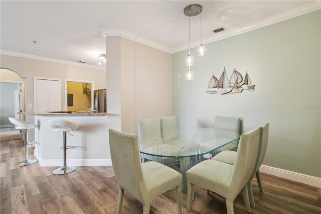 dining room featuring wood-type flooring and crown molding