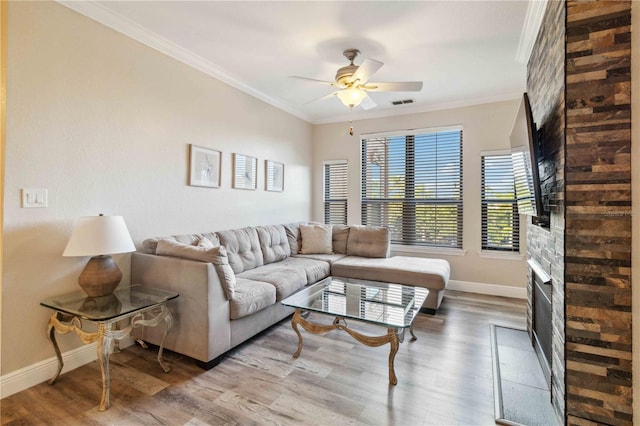 living room featuring light hardwood / wood-style floors, ceiling fan, and crown molding