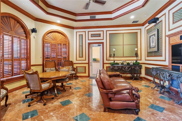 dining space featuring ceiling fan, ornamental molding, and a tray ceiling