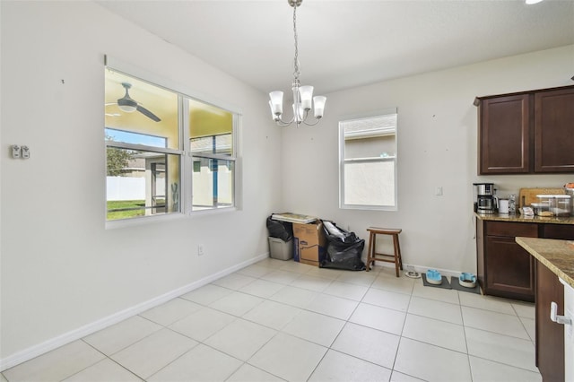 dining space with light tile patterned floors and ceiling fan with notable chandelier