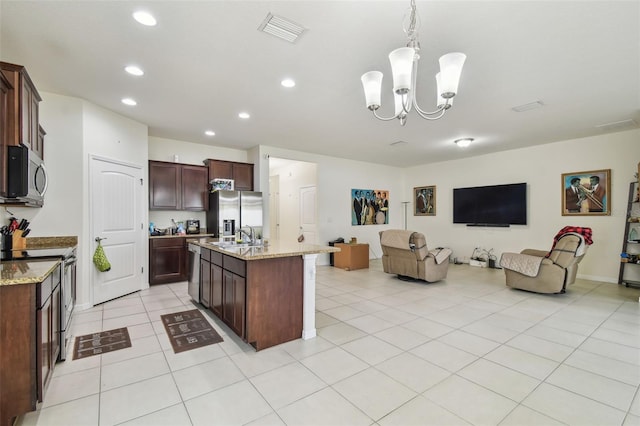 kitchen with a notable chandelier, light stone counters, stainless steel appliances, and hanging light fixtures