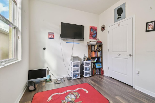 playroom featuring dark wood-type flooring and a healthy amount of sunlight