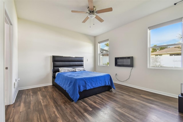 bedroom with a wall mounted air conditioner, multiple windows, dark wood-type flooring, and ceiling fan