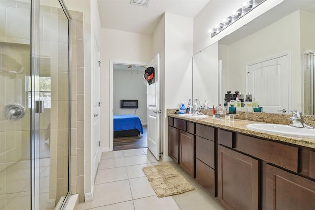 bathroom with tile patterned floors, vanity, and an enclosed shower