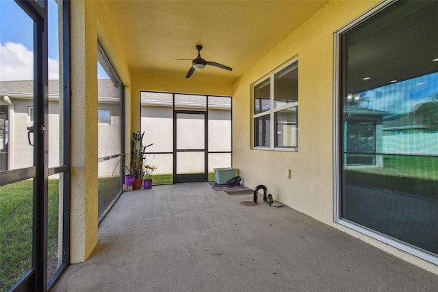 unfurnished sunroom with ceiling fan