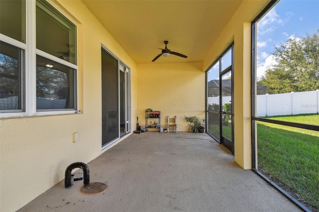 unfurnished sunroom with ceiling fan