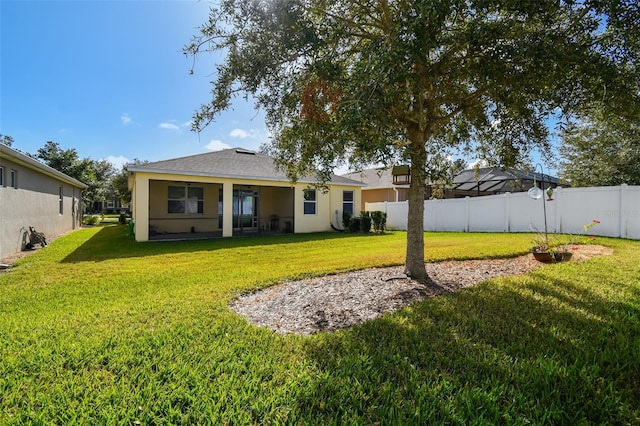 rear view of property featuring a yard