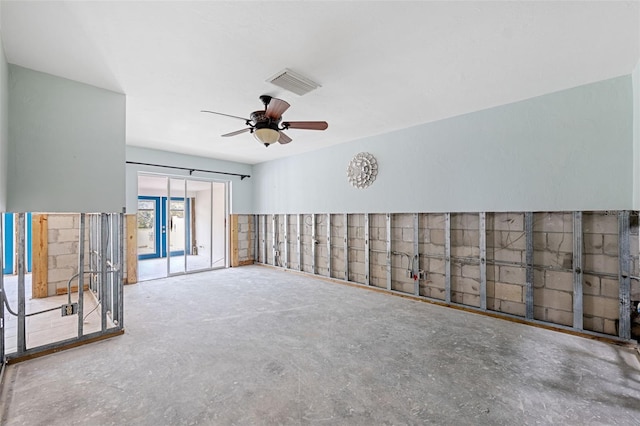 spare room featuring ceiling fan and concrete floors