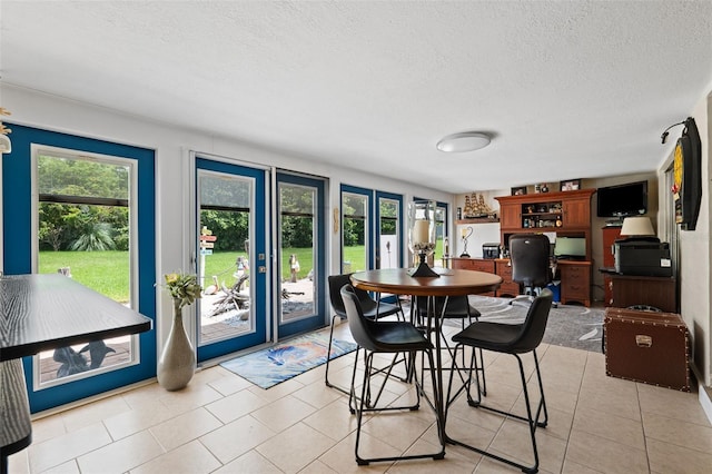 dining area with light tile patterned floors and a textured ceiling