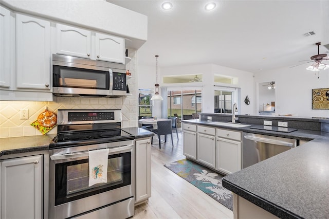 kitchen featuring ceiling fan, sink, pendant lighting, appliances with stainless steel finishes, and light wood-type flooring