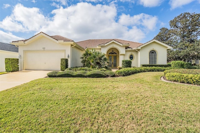 mediterranean / spanish home featuring a garage and a front yard