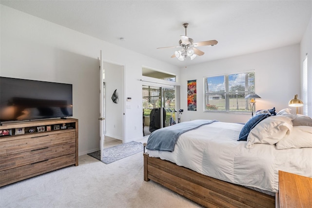 bedroom featuring access to exterior, light colored carpet, multiple windows, and ceiling fan