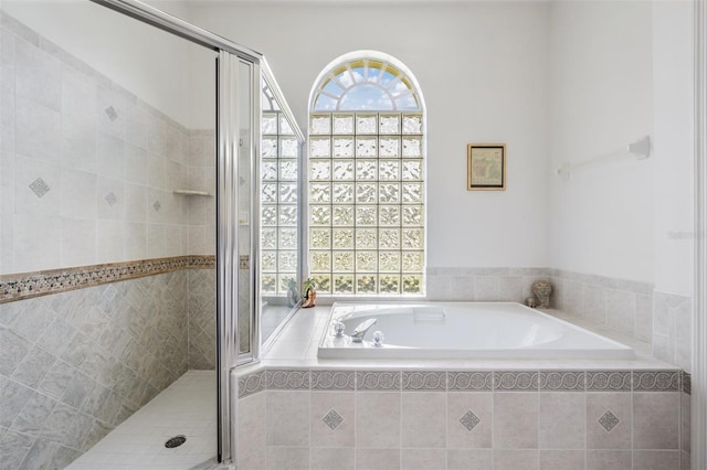 bathroom featuring shower with separate bathtub