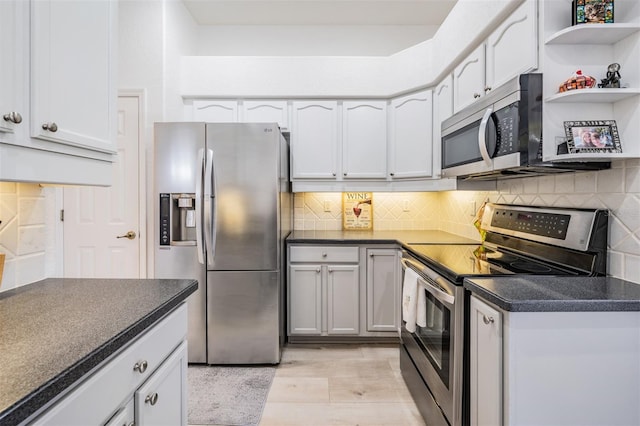 kitchen with backsplash, light wood-type flooring, and appliances with stainless steel finishes