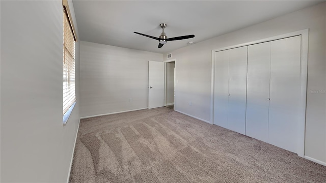 unfurnished bedroom with ceiling fan, light colored carpet, and a closet