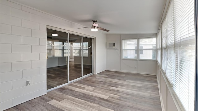 unfurnished sunroom featuring an AC wall unit, ceiling fan, and vaulted ceiling