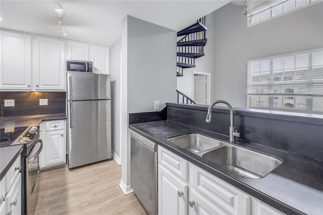501 Knights Run Ave Unit 2308, Tampa, FL 33602 - kitchen with sink, rail lighting, appliances with stainless steel finishes, white cabinets, and light wood-type flooring