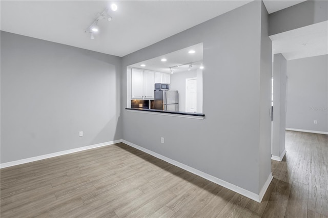 501 Knights Run Ave Unit 2308, Tampa, FL 33602 - unfurnished living room featuring rail lighting and light hardwood / wood-style flooring