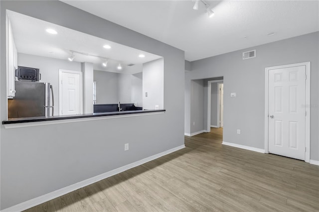 501 Knights Run Ave Unit 2308, Tampa, FL 33602 - unfurnished living room with light hardwood / wood-style flooring and rail lighting