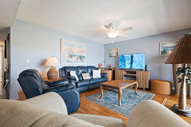 living room featuring ceiling fan, a textured ceiling, and light hardwood / wood-style flooring