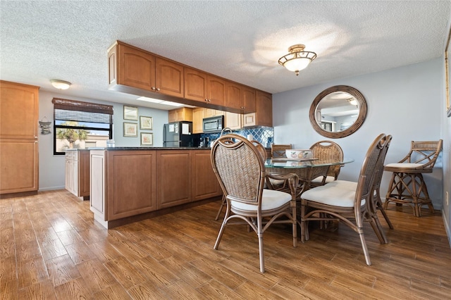 dining space featuring hardwood / wood-style floors and a textured ceiling