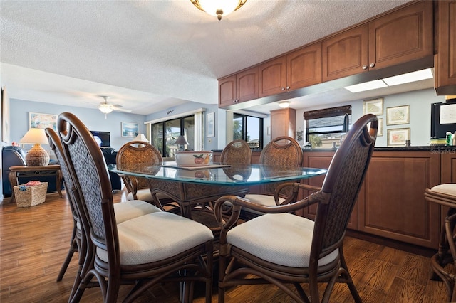 dining area with a textured ceiling, dark hardwood / wood-style floors, and ceiling fan