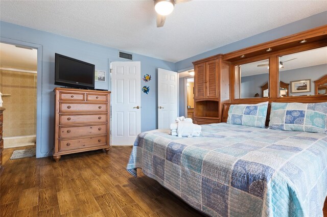 bedroom with a textured ceiling, dark hardwood / wood-style floors, and ceiling fan